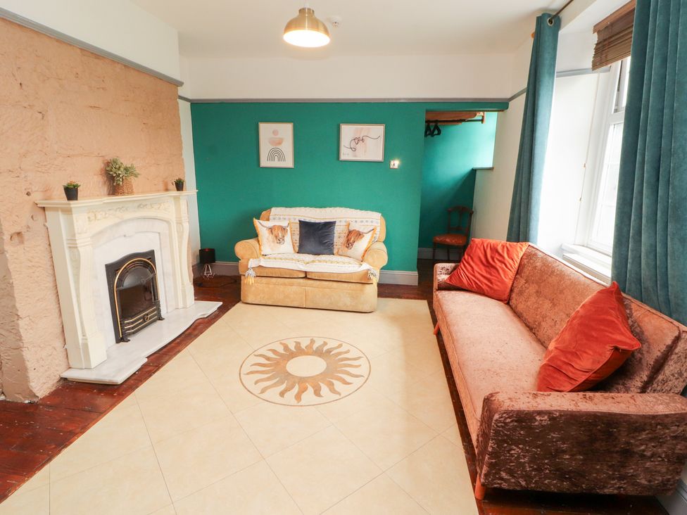 A living room with a fireplace and two sofas at 1 Cleator Gate in Cleator