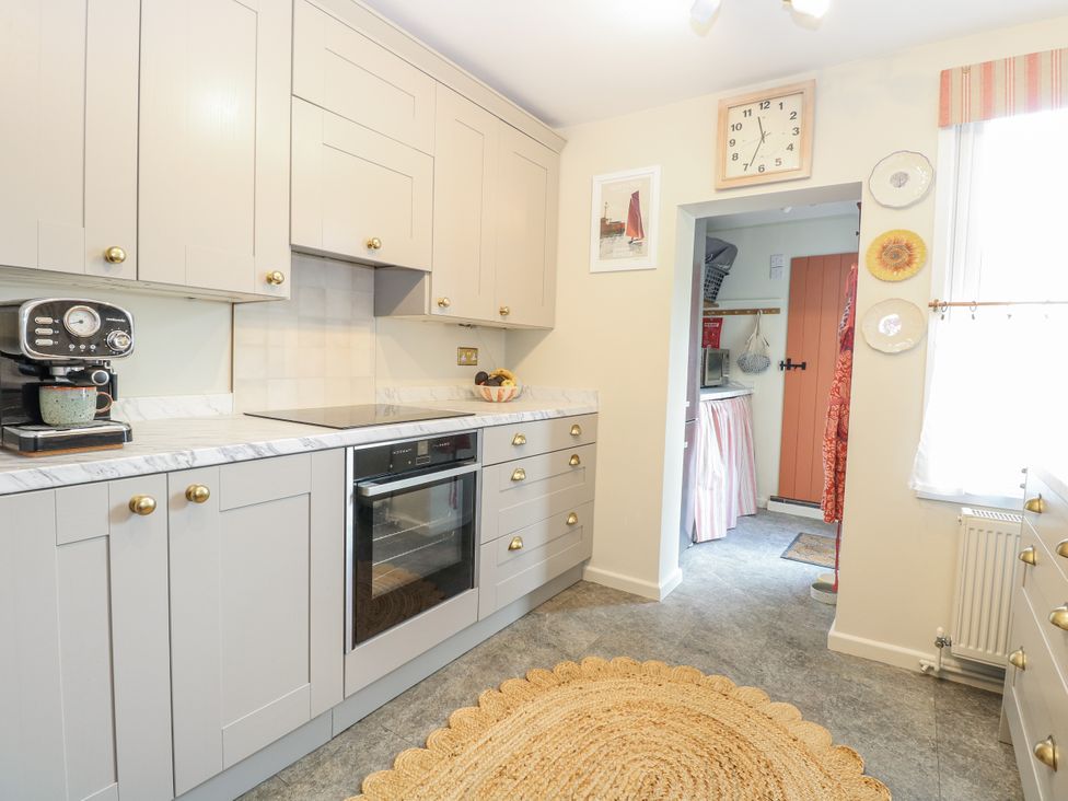 A kitchen with cabinets and a coffee maker at 18 Pakefield Road in Lowestoft