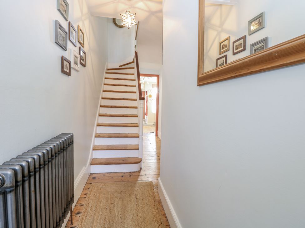 A hallway with a staircase and photo frames at 18 Pakefield Road in Lowestoft