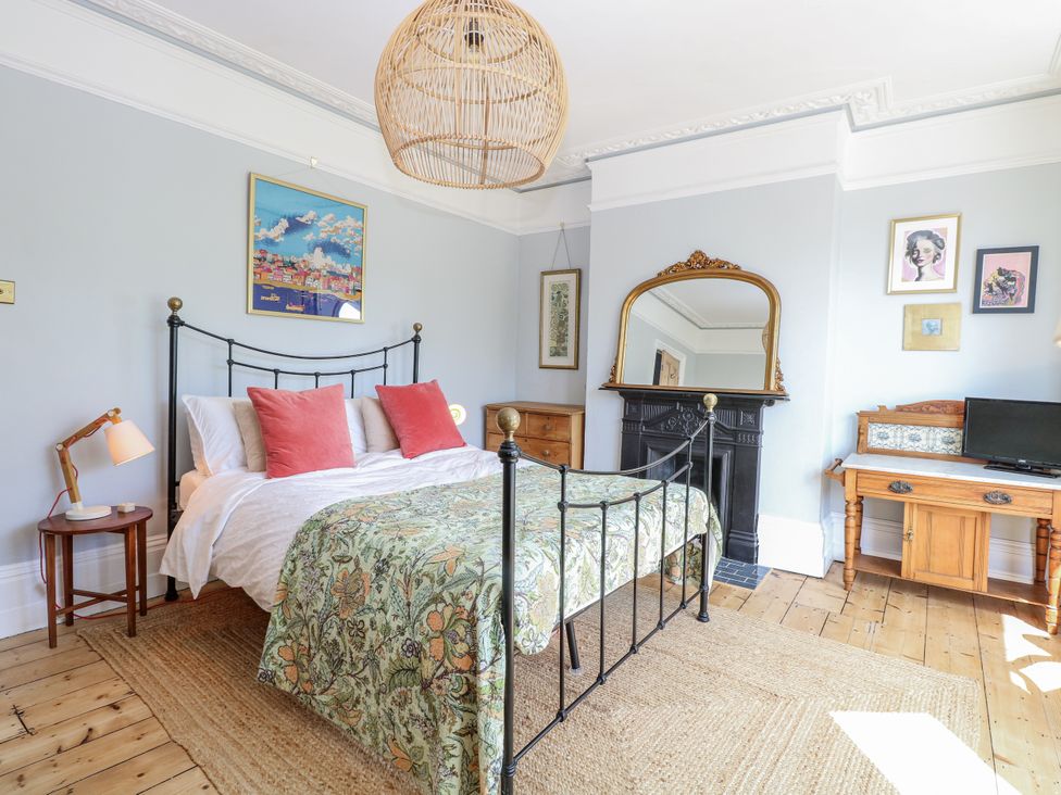 A bedroom with a bed and artwork at 18 Pakefield Road in Lowestoft