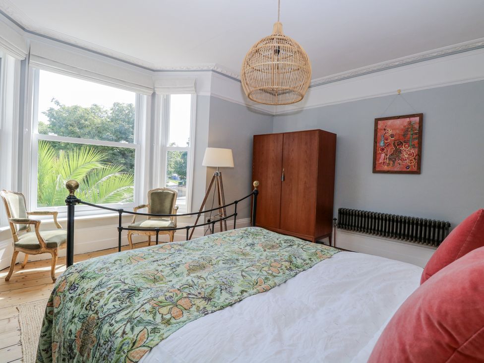 A bedroom with a bed, wardrobe, and lamp at 18 Pakefield Road in Lowestoft