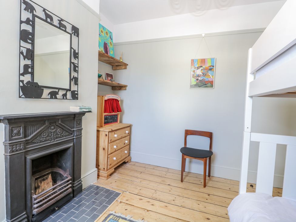 A bedroom with a fireplace and furniture at 18 Pakefield Road in Lowestoft