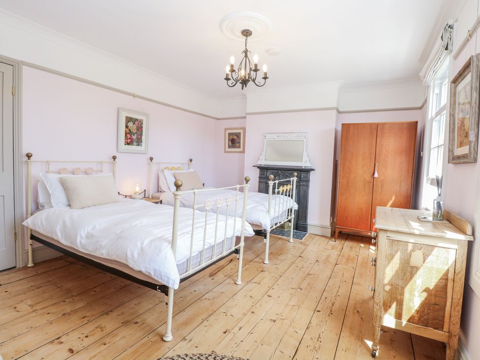 A bedroom with two beds and a wardrobe at 18 Pakefield Road in Lowestoft