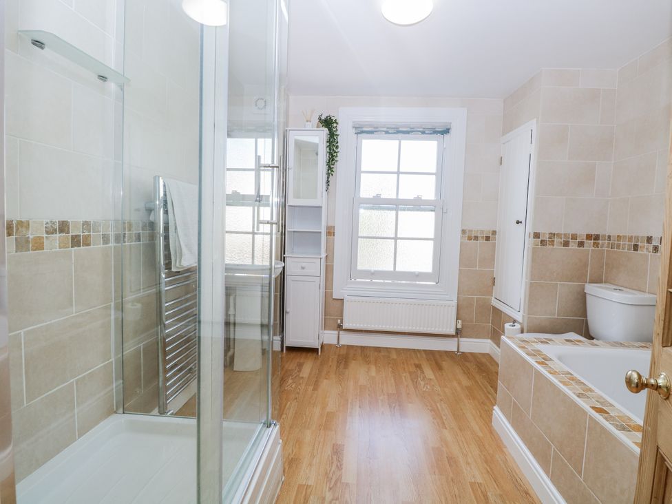 A bathroom with a shower, bathtub, and sink at 18 Pakefield Road in Lowestoft