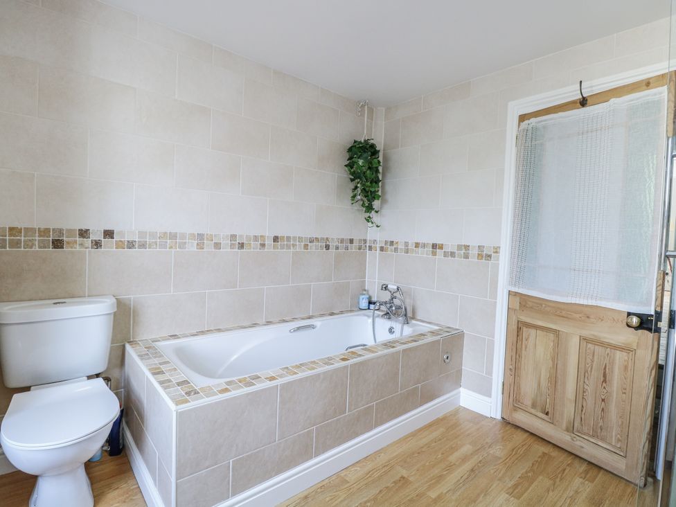 A bathroom with a toilet and bathtub at 18 Pakefield Road in Lowestoft
