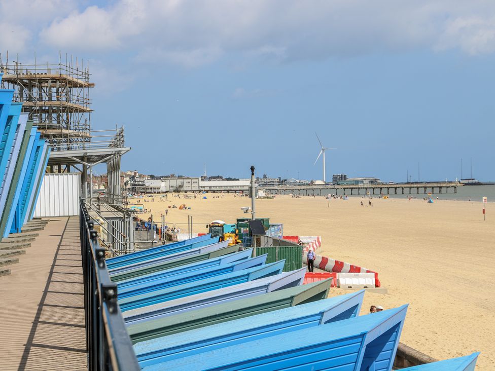 A beach scene with beach huts and a pier at 18 Pakefield Road Lowestoft