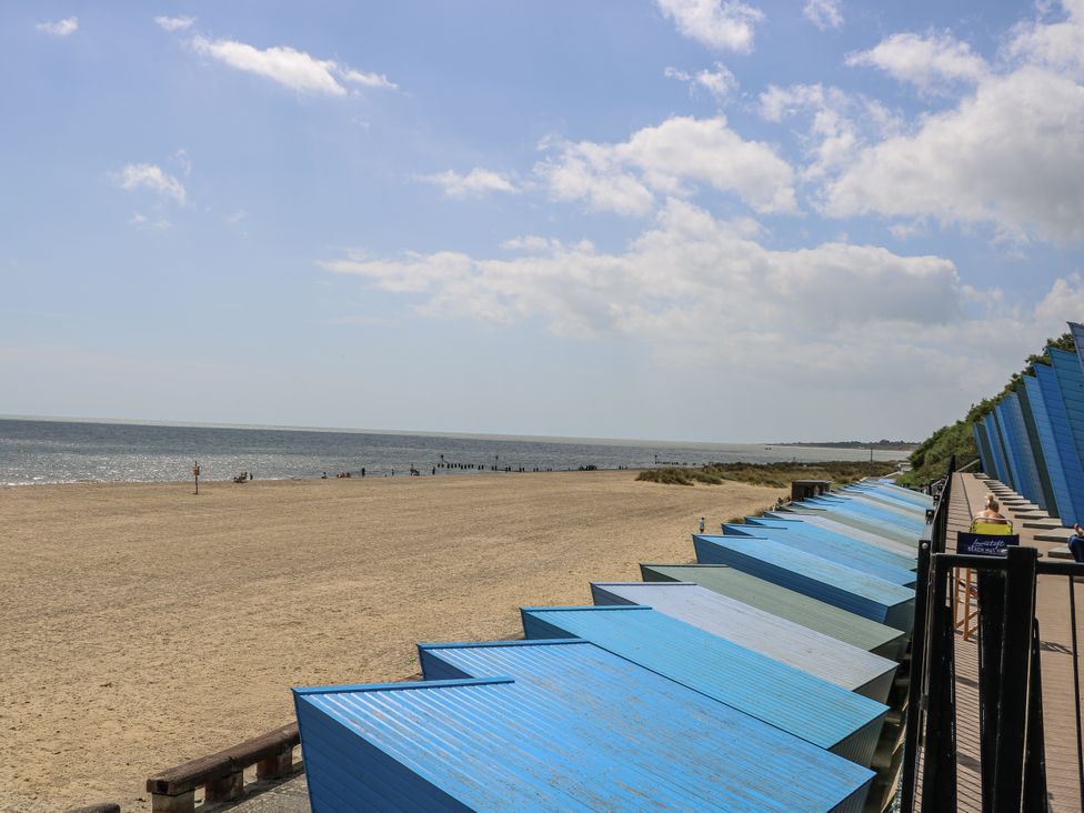 A beach with blue beach huts and a sea view at 18 Pakefield Road in Lowestoft