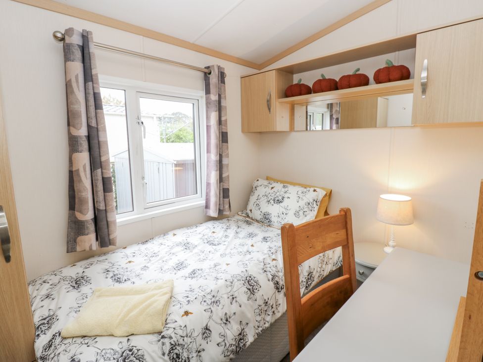 A bedroom with a bed and a desk at Cate’s Cozy Cabin in High Hesket near Lazonby