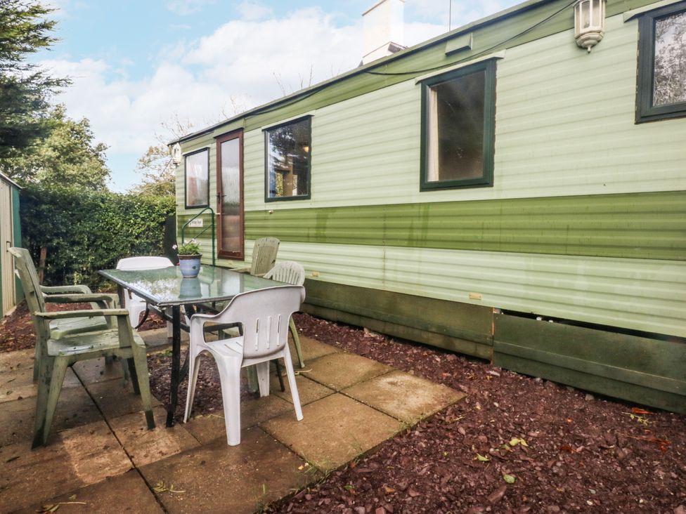 An outdoor seating area with a table and chairs at Meadow Island Caravan