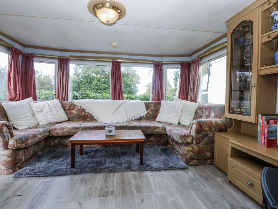 A living room with a sofa and coffee table at Meadow Island Caravan