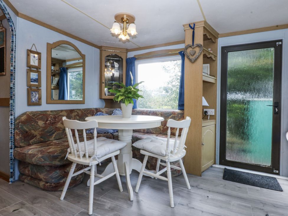 A dining room with a table and chairs at Meadow Island Caravan 