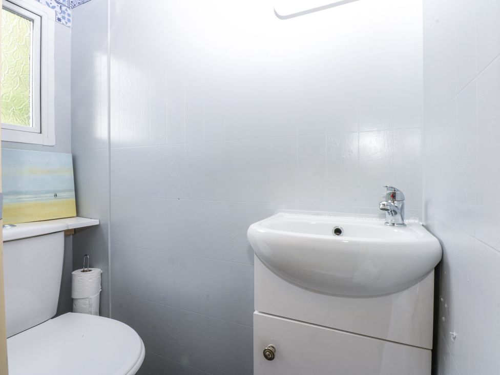 A bathroom with a toilet and washbasin at Meadow Island Caravan 