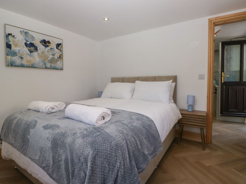 A bedroom with a bed and bedside table at Old Post Office Cottage in Ulverston