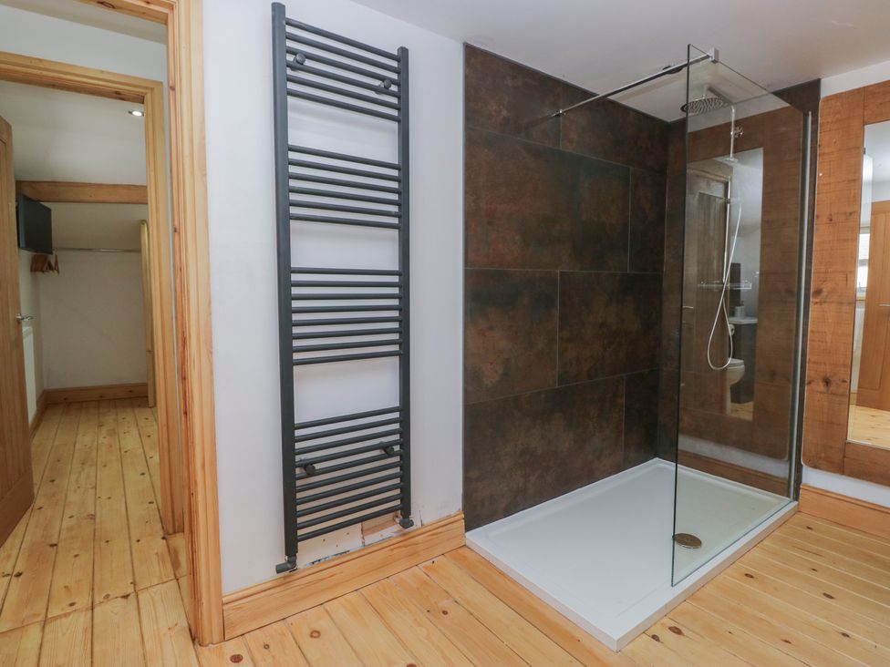 A bathroom with a shower and towel radiator at Old Post Office Cottage in Ulverston