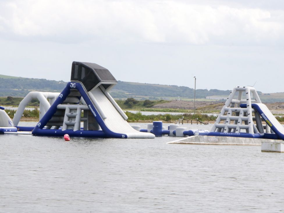 An inflatable water park with slides and obstacles at Old Post Office Cottage Backbarrow near Newby Bridge