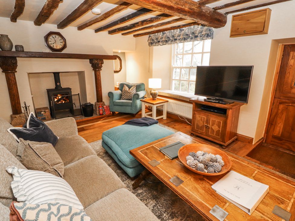 A living room with a sofa and armchair at Deer How Farm in Patterdale near Glenridding
