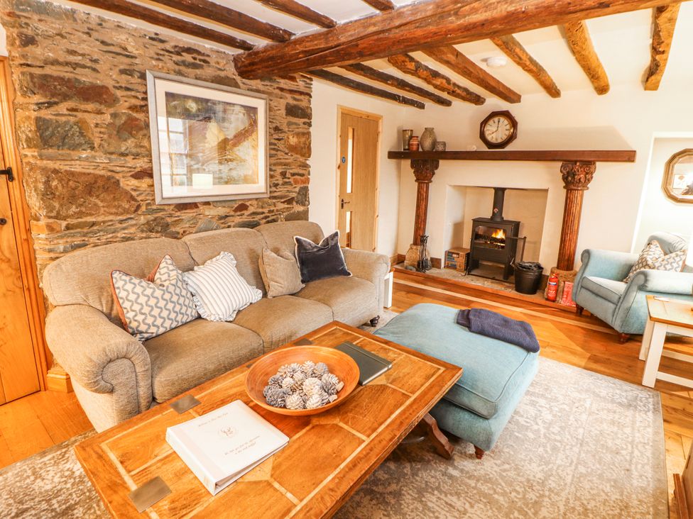 A living room with a sofa and fireplace at Deer How Farm Patterdale near Glenridding