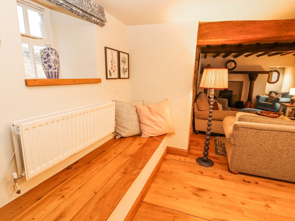 A living room with a window, radiator, and seating area at Deer How Farm in Patterdale near Glenridding