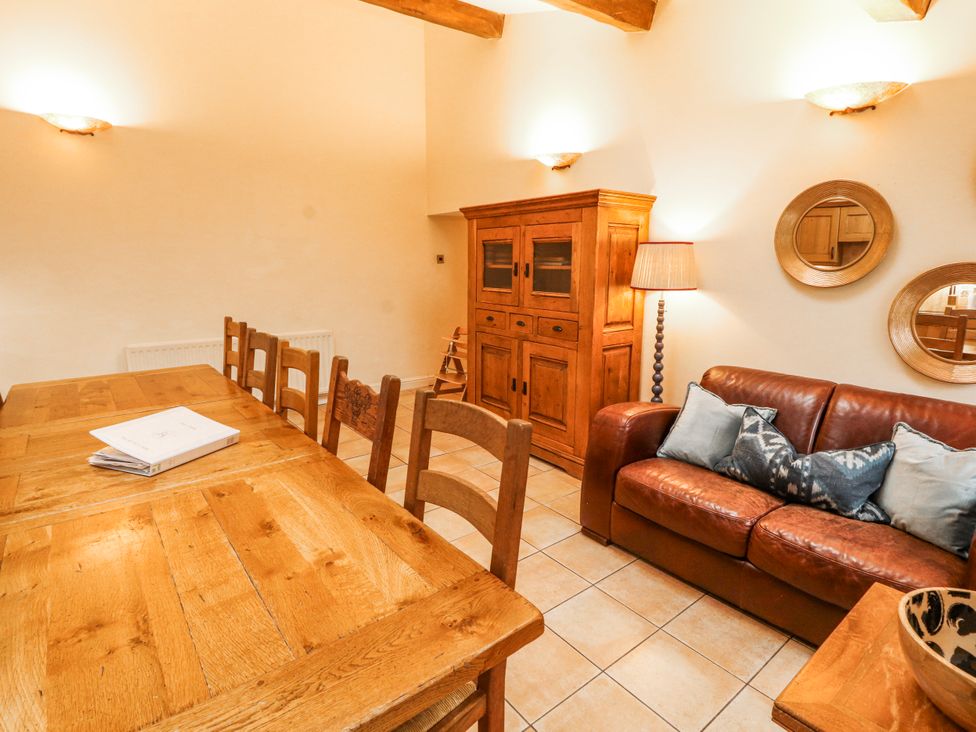 A dining room with a wooden table and chairs at Deer How Farm in Patterdale near Glenridding