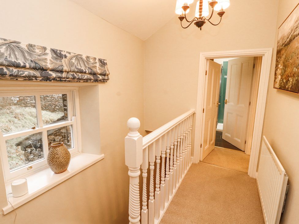A hallway with a staircase and a window at Deer How Farm Patterdale near Glenridding