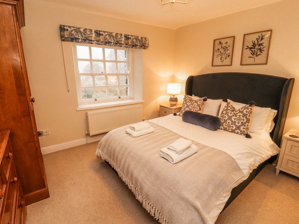 A bedroom with a bed and lamp at Deer How Farm in Patterdale near Glenridding