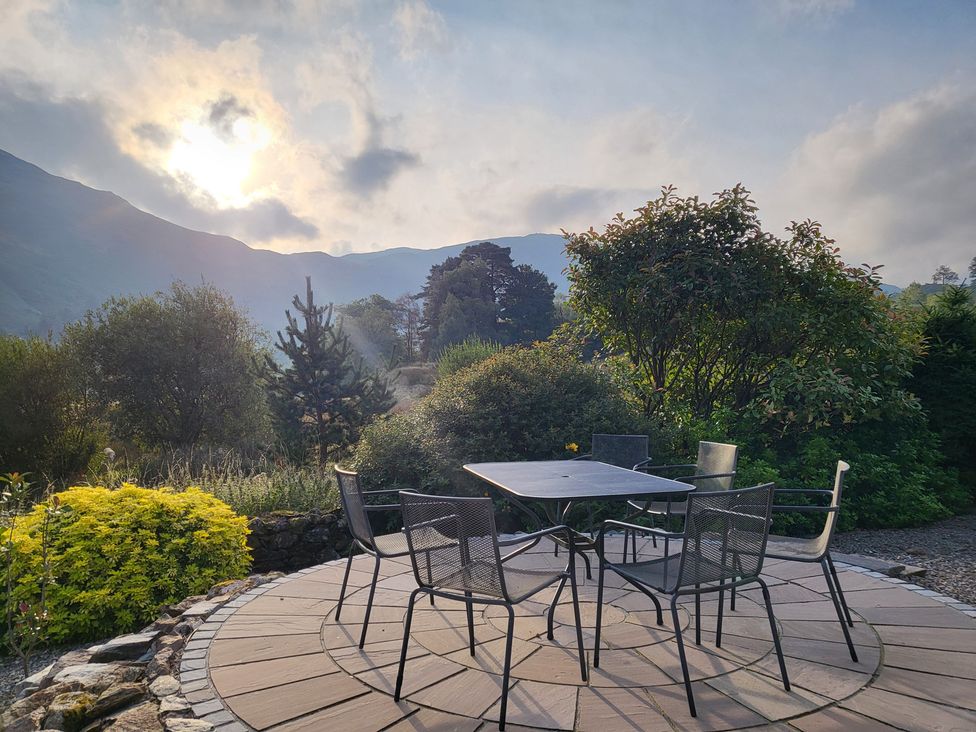 An outdoor seating area with a table and chairs at Deer How Farm Patterdale near Glenridding