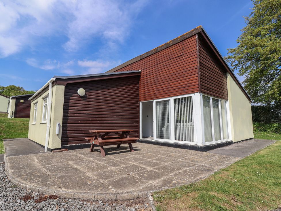 A house with a patio and table at Babbacombe Breeze in Chudleigh