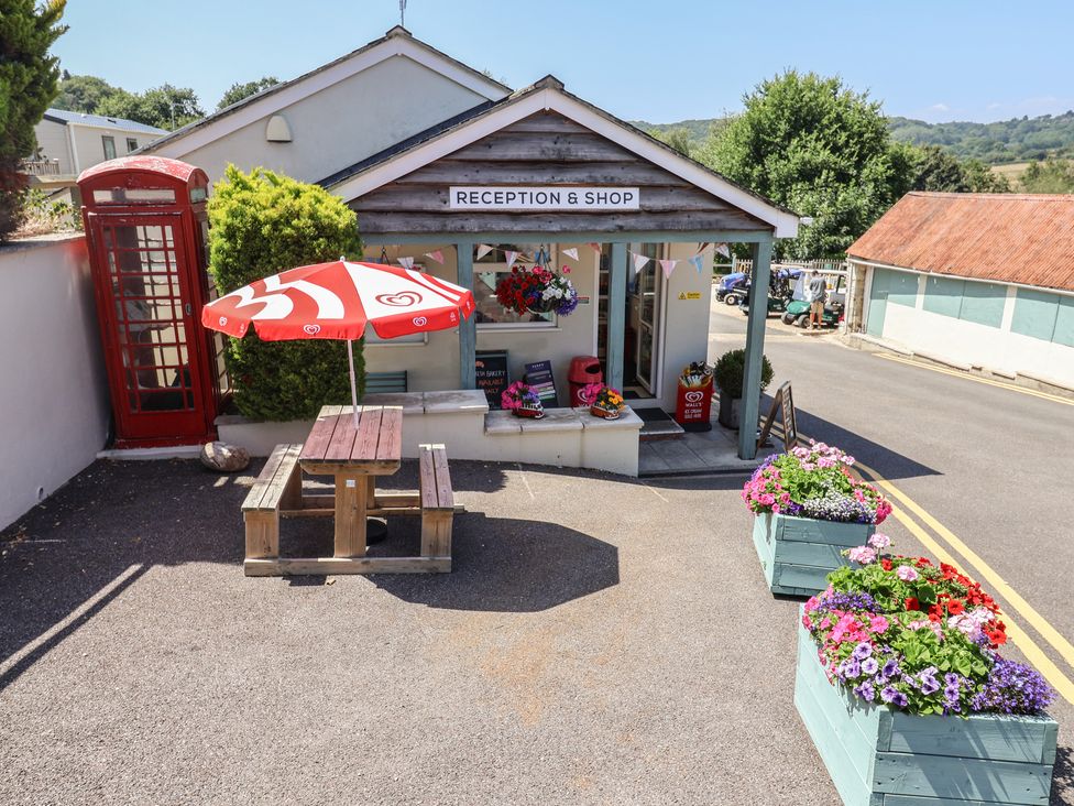 An outdoor reception area with a shop sign at Willow's Leap in Uplyme
