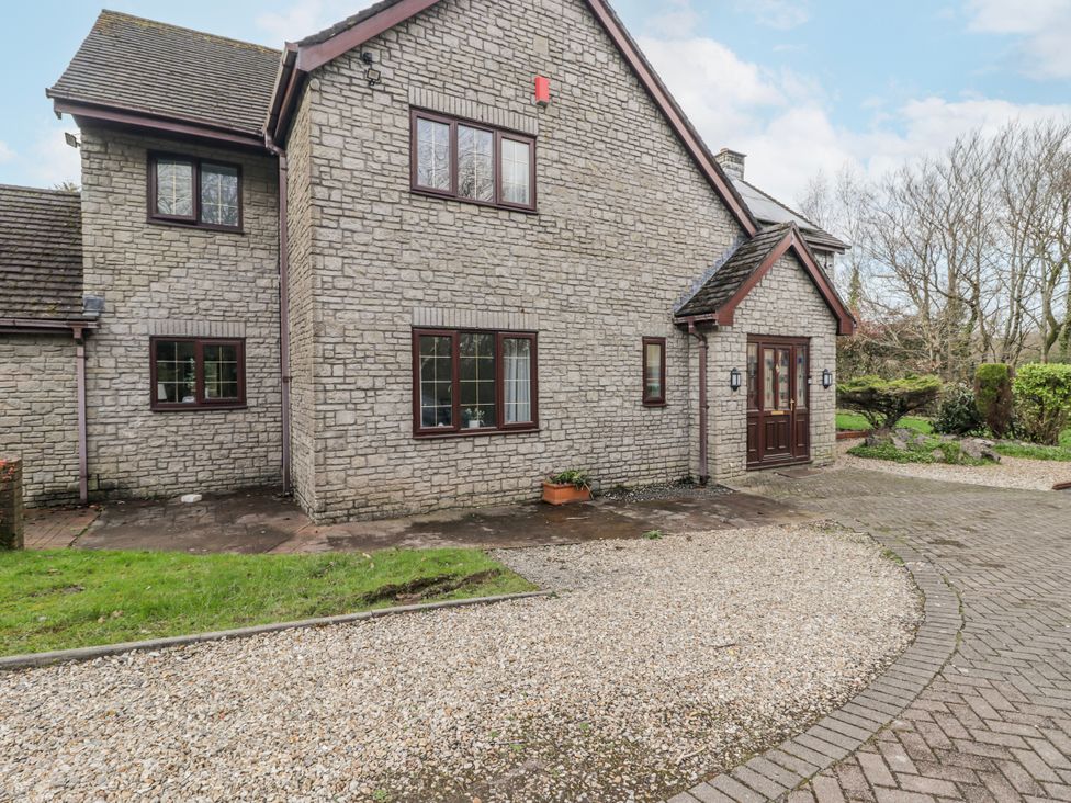 A house exterior with a stone wall and gravel driveway at Carreg Llwyd Groeswen near Trecenydd