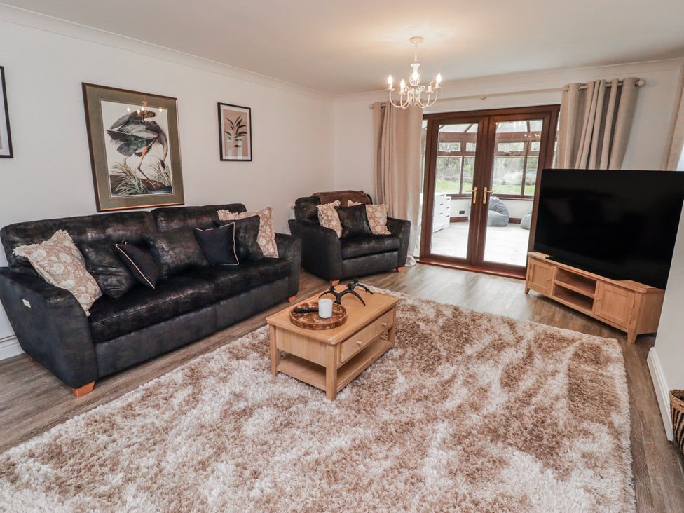 A living room with sofas and a television at Carreg Llwyd Groeswen near Trecenydd