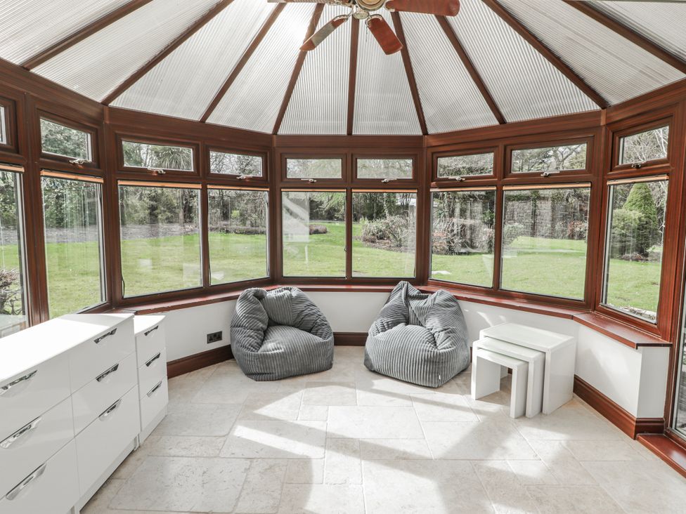A conservatory with bean bags and a table at Carreg Llwyd in Groeswen near Trecenydd