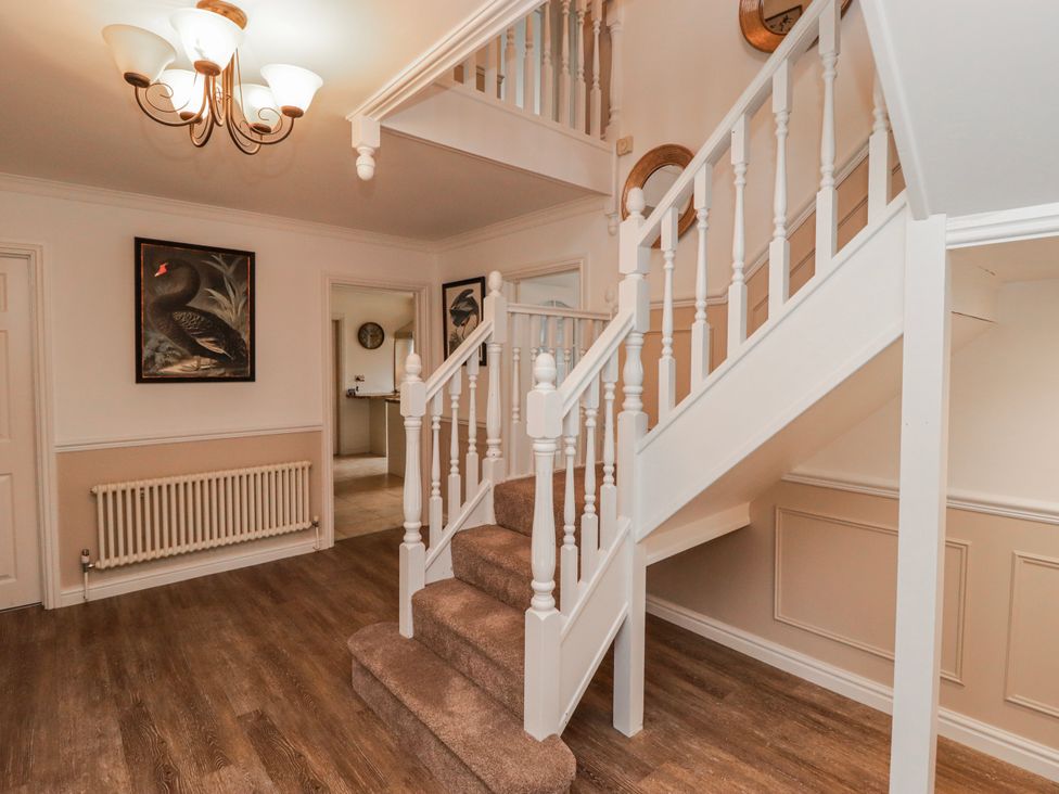 A staircase and hallway with wall art at Carreg Llwyd in Groeswen near Trecenydd