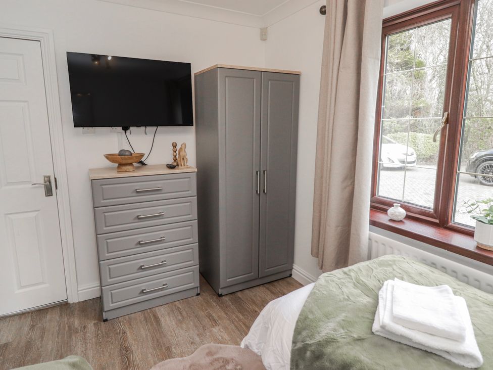 A bedroom with a television and dresser at Carreg Llwyd in Groeswen near Trecenydd
