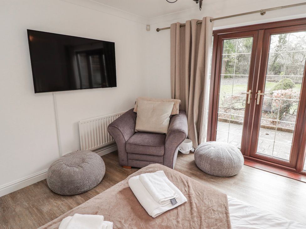 A snug with a television and armchair at Carreg Llwyd Groeswen near Trecenydd