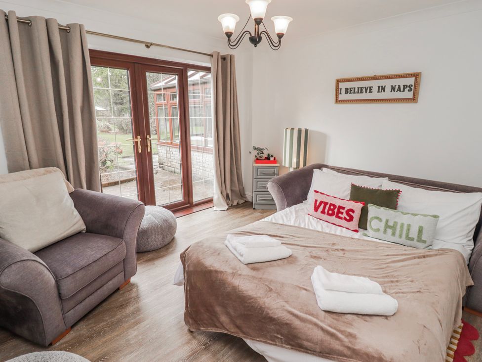 A living room with a sofa and armchair at Carreg Llwyd Groeswen near Trecenydd
