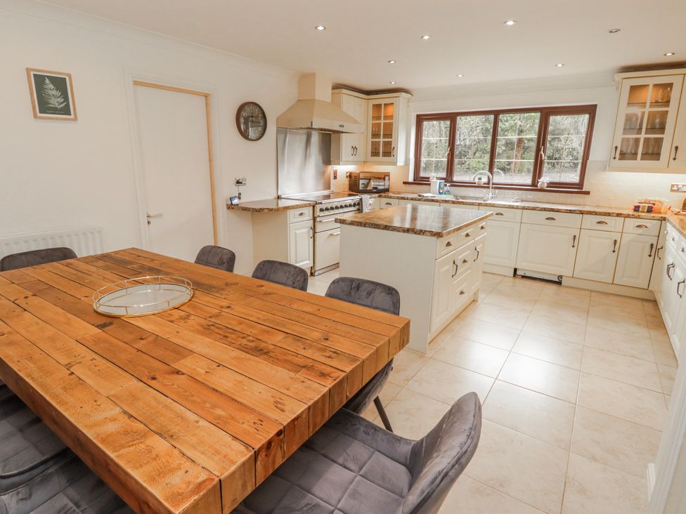 A kitchen with a wooden table and chairs at Carreg Llwyd Groeswen near Trecenydd