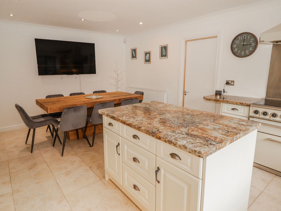 A kitchen with dining table and chairs at Carreg Llwyd in Groeswen near Trecenydd