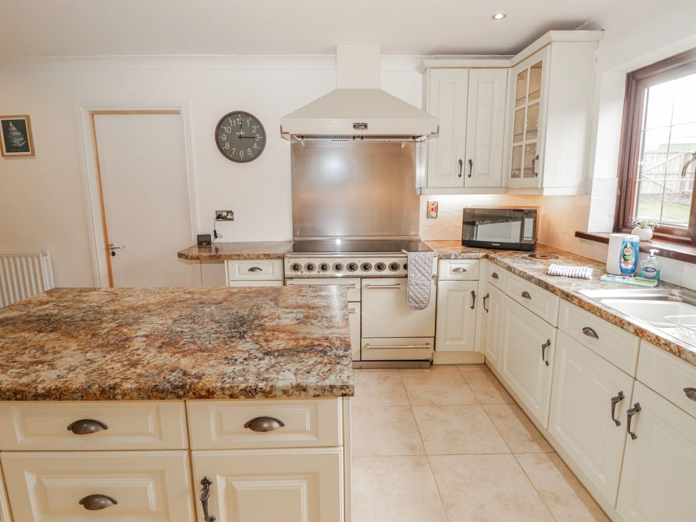 A kitchen with oven, microwave, and sink at Carreg Llwyd near Groeswen