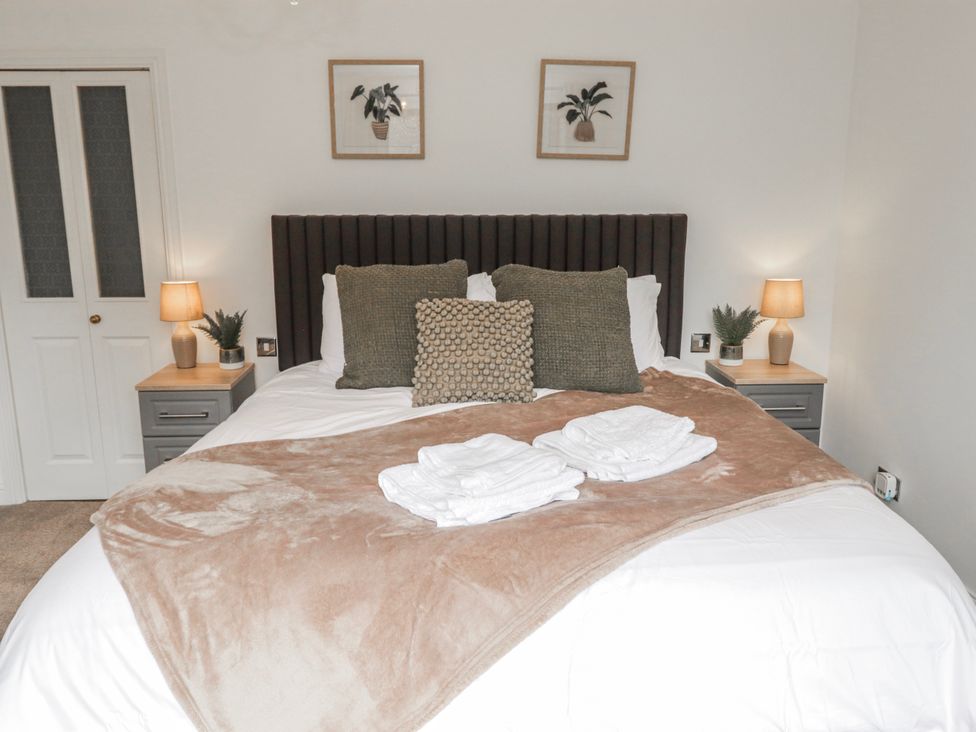A bedroom with a bed and nightstands at Carreg Llwyd in Groeswen near Trecenydd