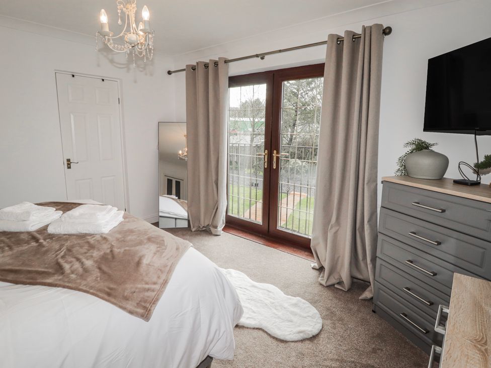A bedroom with a bed and television at Carreg Llwyd near Trecenydd