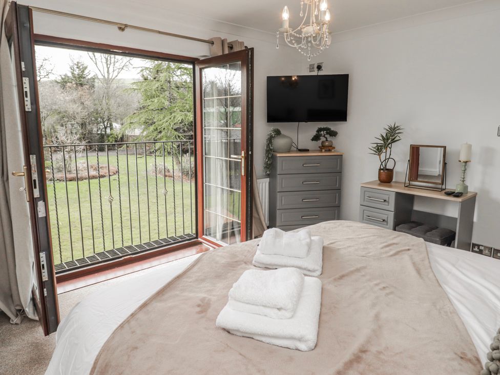A bedroom with a bed and balcony at Carreg Llwyd Groeswen near Trecenydd