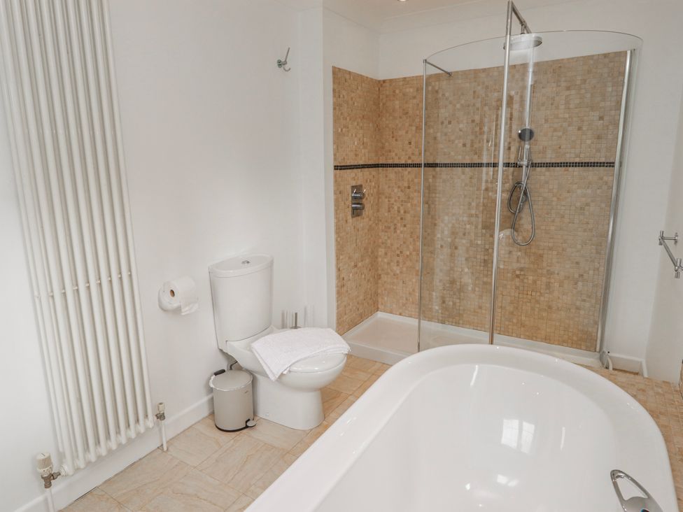 A bathroom with a shower, toilet, and bathtub at Carreg Llwyd in Groeswen near Trecenydd