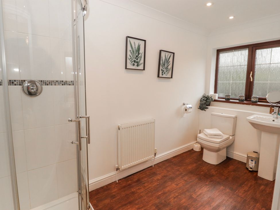 A bathroom with a shower, sink, and toilet at Carreg Llwyd in Groeswen near Trecenydd