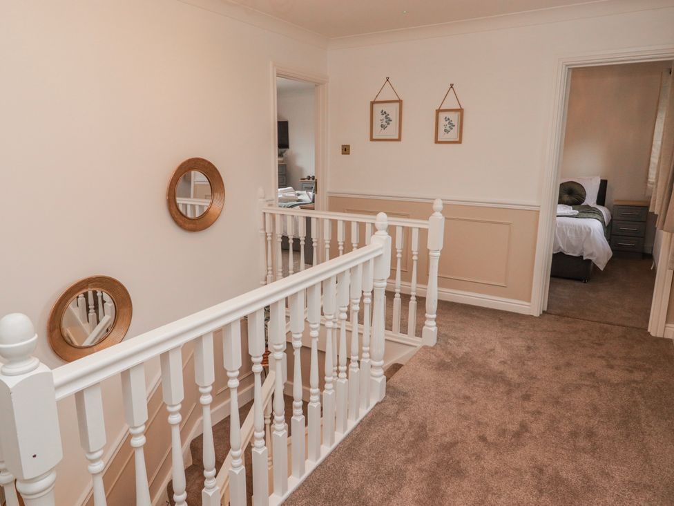 A hallway with stair railing and mirrors at Carreg Llwyd in Groeswen near Trecenydd