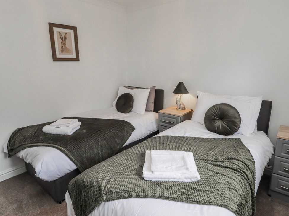 A bedroom with two single beds and a lamp at Carreg Llwyd Groeswen near Trecenydd