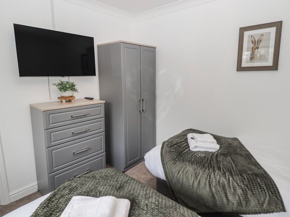 A bedroom with a television and a wardrobe at Carreg Llwyd in Groeswen near Trecenydd