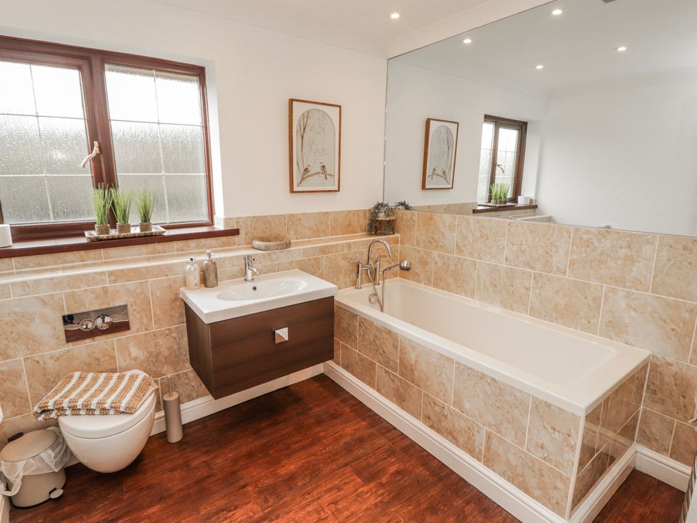 A bathroom with a bathtub and sink at Carreg Llwyd Groeswen near Trecenydd