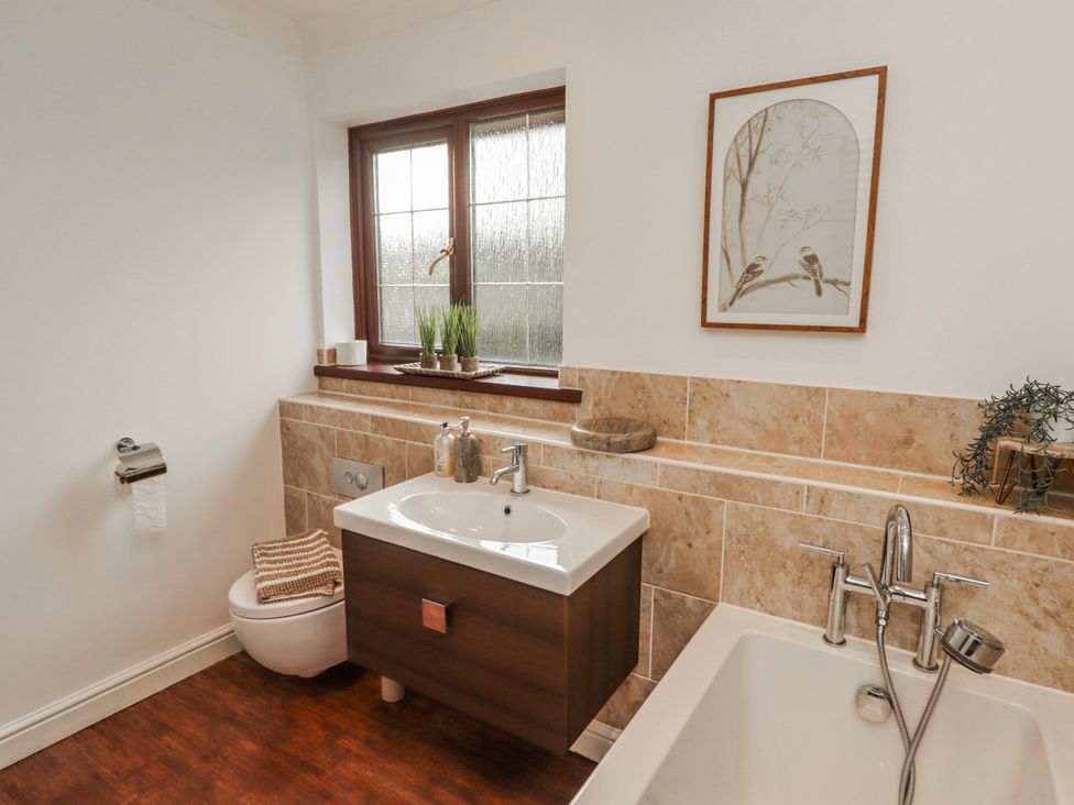 A bathroom with a sink, bathtub, and toilet at Carreg Llwyd, Groeswen near Trecenydd