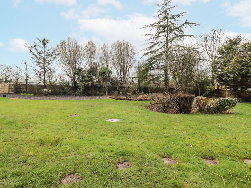 A garden with grass, trees, and a fence at Carreg Llwyd Groeswen near Trecenydd