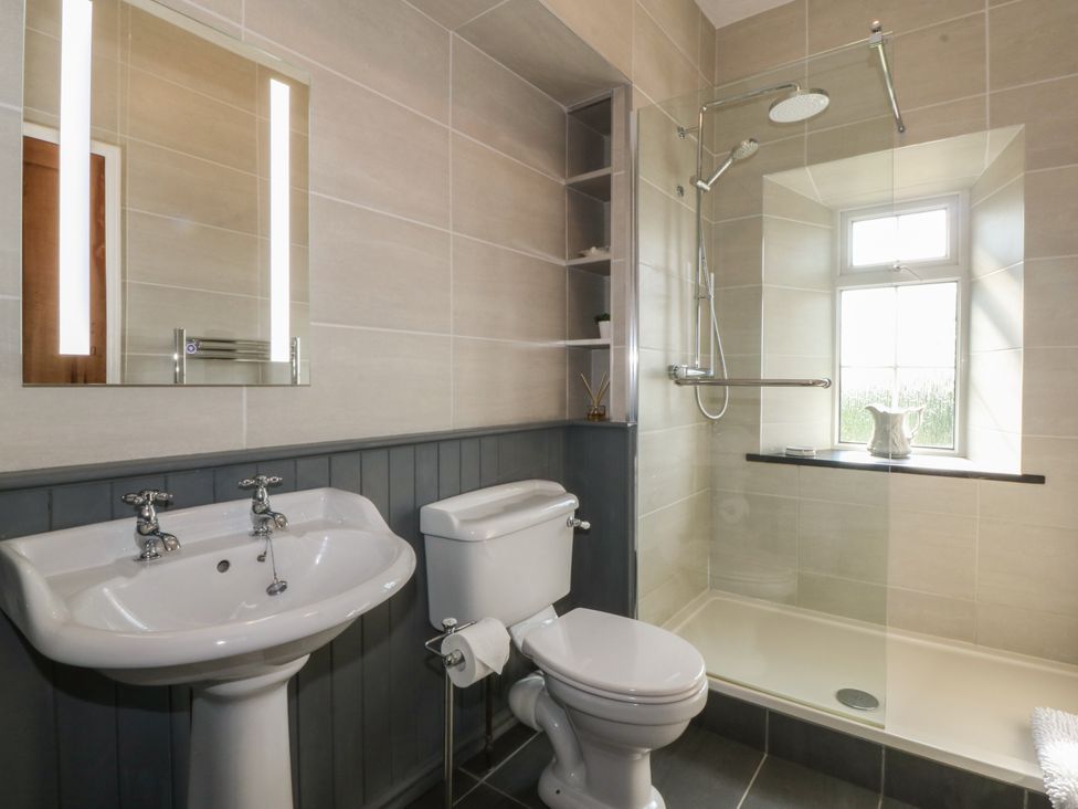 A bathroom with a sink toilet and walk in shower at Glasfryn in Llandwrog